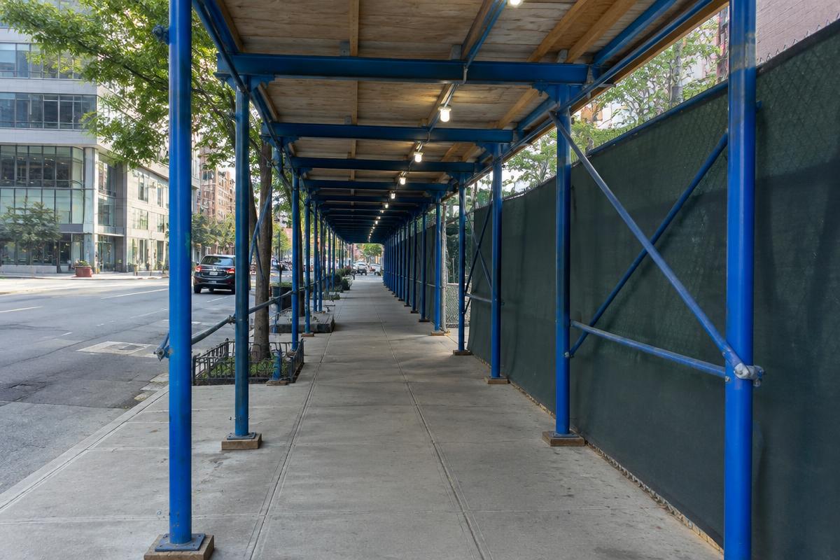 Sidewalk shed and construction fence along a New York City sidewalk